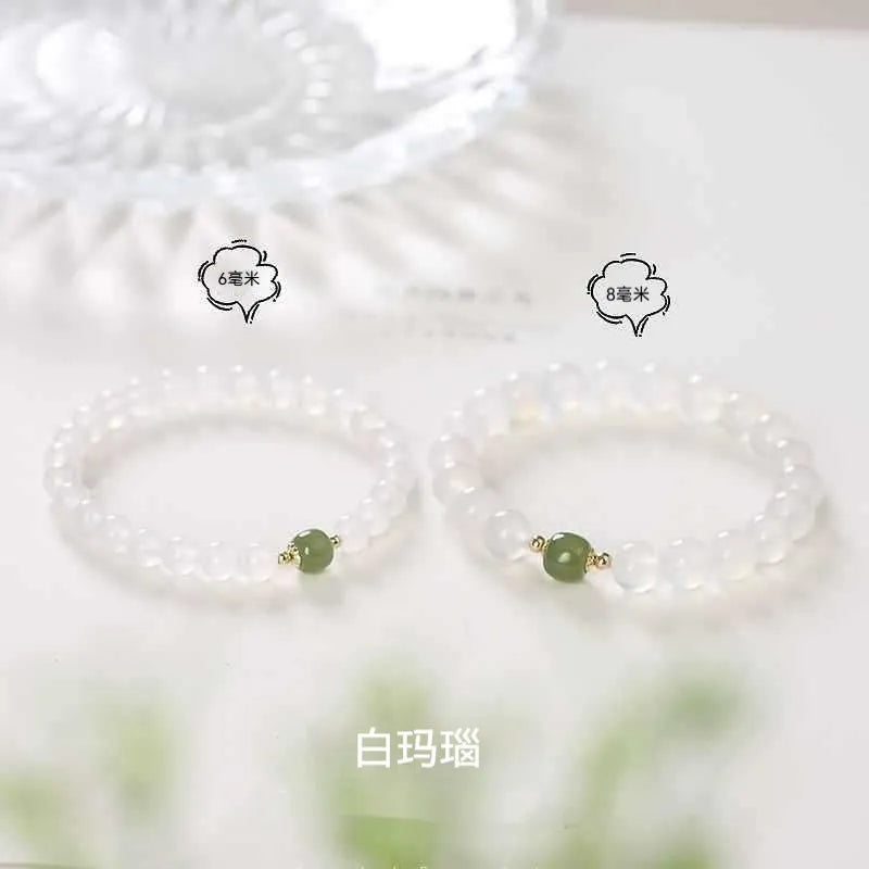 Handmade white agate and crystal bracelet with cinnabar inlay showing letter modelling on 8mm beads.