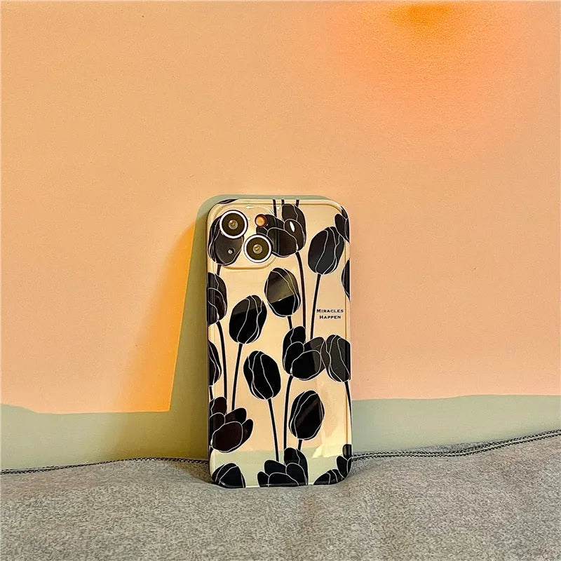Black silicone iPhone case with a printed white and grey tulip floral design on the back.