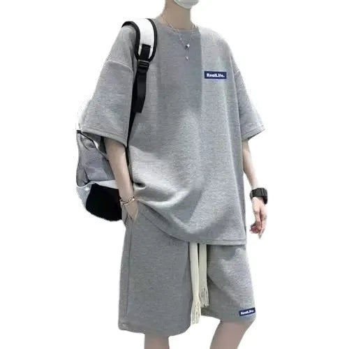 A man modelling a waffle-patterned grey short-sleeve top and matching shorts leisure set.