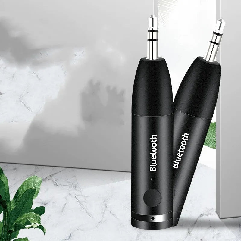 Black AUX Bluetooth 5.0 audio receiver for car stereo with USB cable.