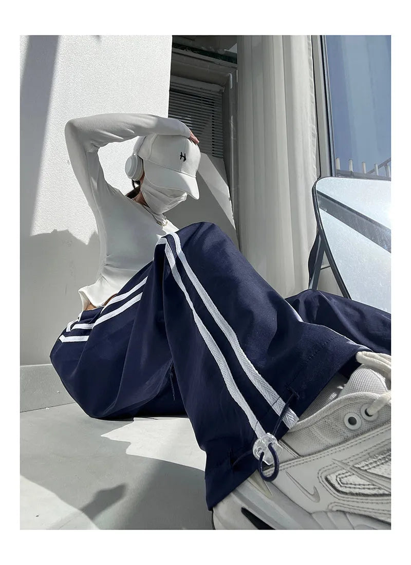 Navy blue and white loose straight leg trousers with ribbon parallel bars detail.