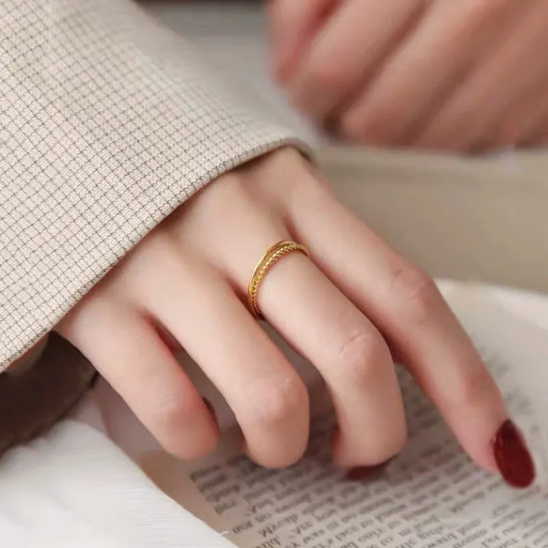 A brass gold plated women's ring in a simple bracelet design, shown in glossy, matte, and twist style variations.