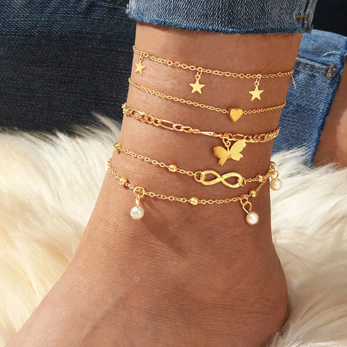 Set of four alloy anklets with butterfly, pearl, and heart designs on a white background.