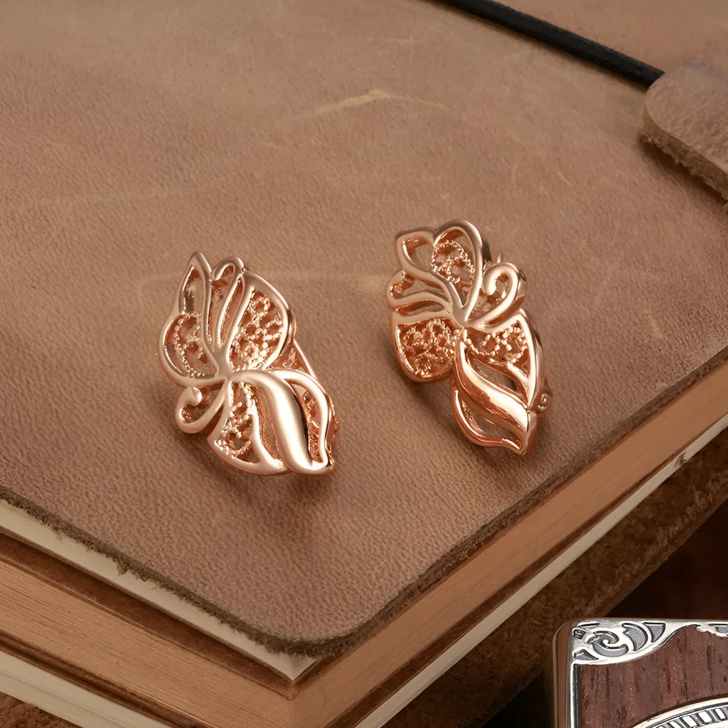 Pair of rose gold hollow carved geometric earrings with rhinestone accents on copper base
