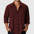 Man wearing a loose-fit long-sleeve polyester shirt with a stand collar, ideal for beach holidays.