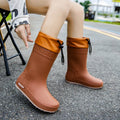 Women's solid colour PVC rain boots with non-slip soles in apricot, black, brown, and pink waterproof mouth designs