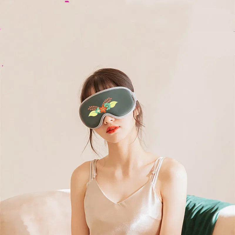 Green portable eye massage mask with USB cable on a grey background