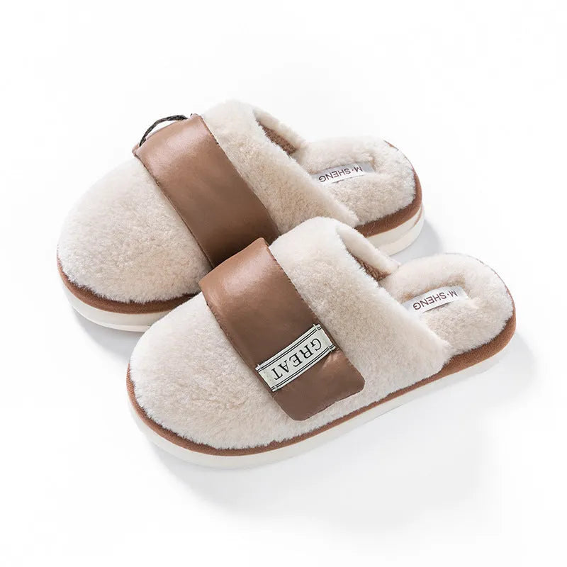 Women's beige plush slipper with Velcro strap and non-slip plastic sole on a wooden floor.