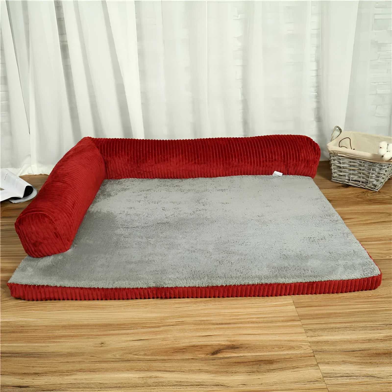 Corduroy pet sofa dog bed with bolster sides, shown in grey colour on a wooden floor