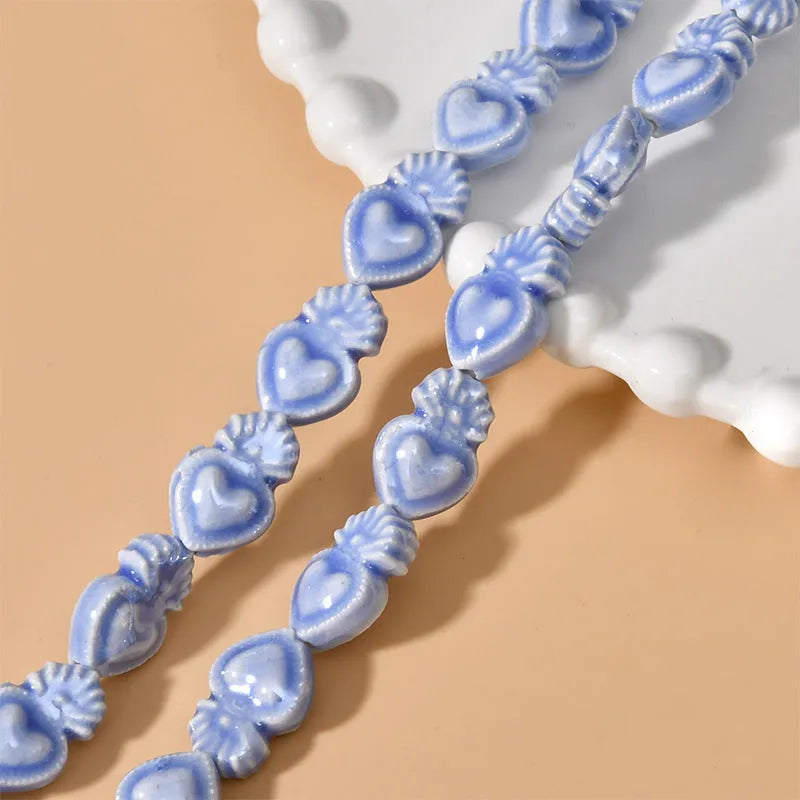 Assorted small ceramic torch beads in multiple colours on a white background.