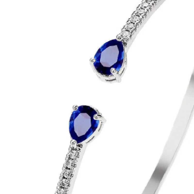 Copper bracelet with inlaid zircon stones in a simple design, shown in white and blue colour options.