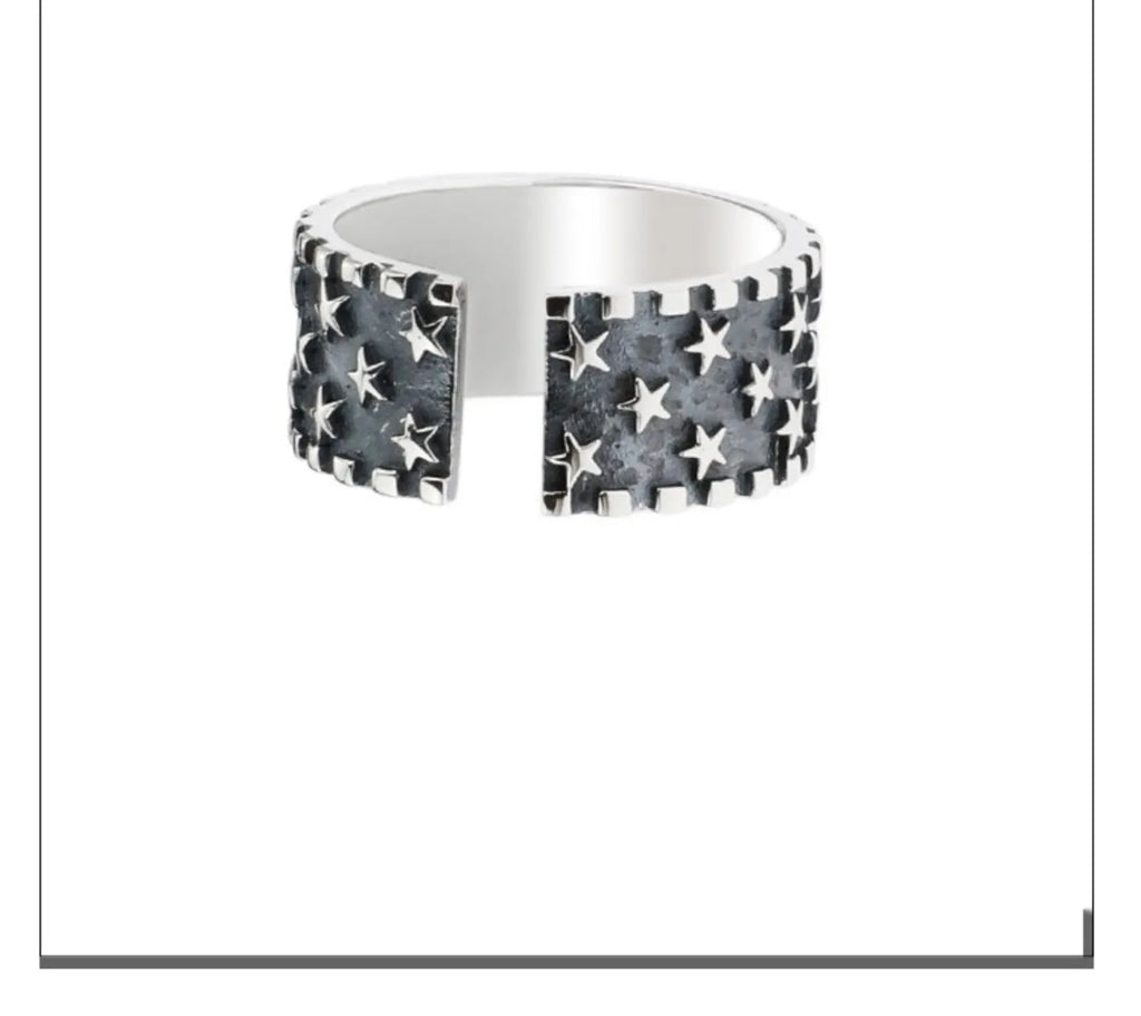 Adjustable sterling silver ring featuring a raised five-pointed star geometric pattern on the band.
