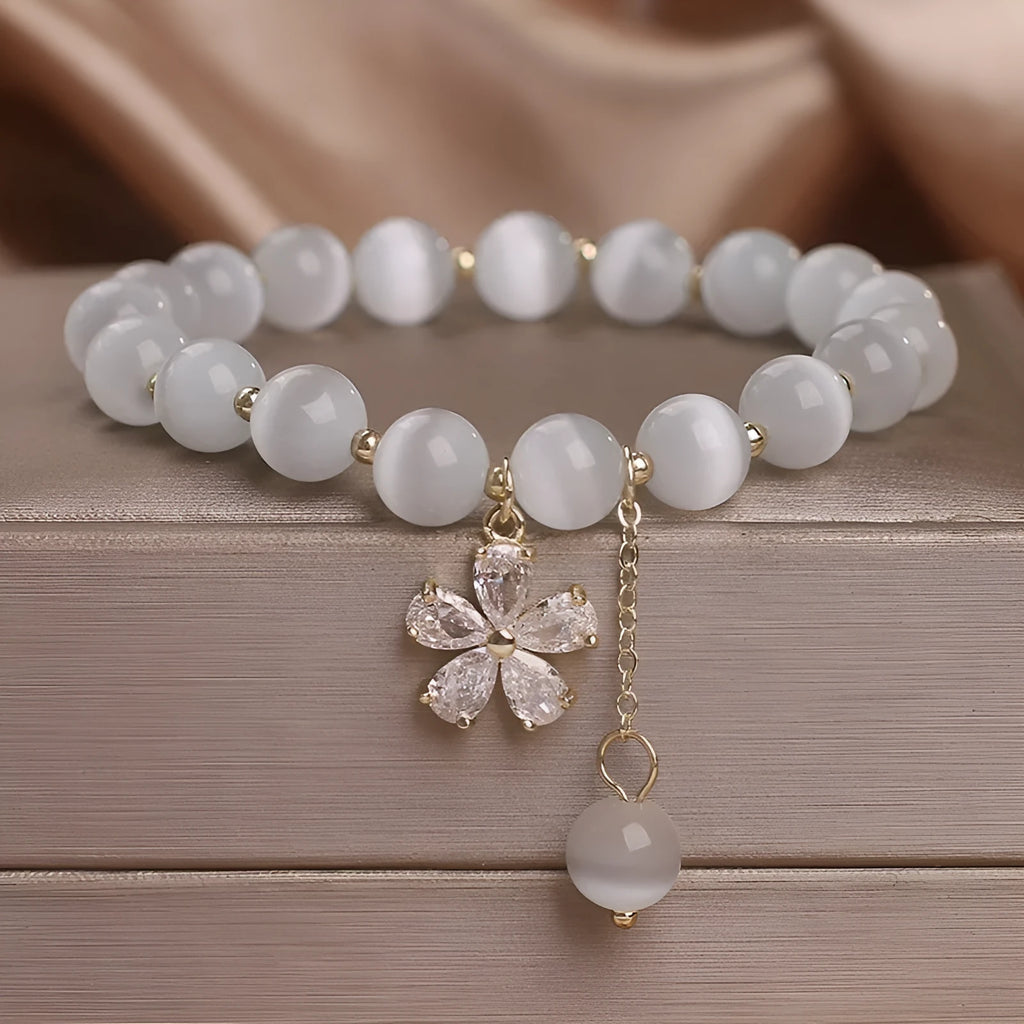 White cat's eye stone women's bracelet with flower tassel and safety buckle.