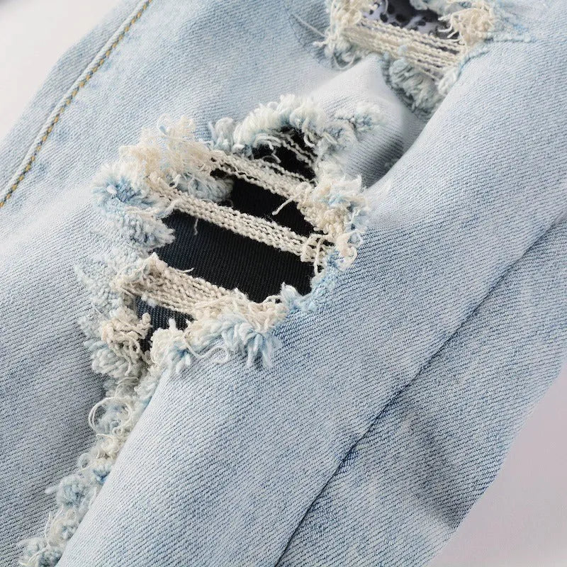 Light blue men's elastic slim fit jeans with hot diamond patch and whisker scrape detailing