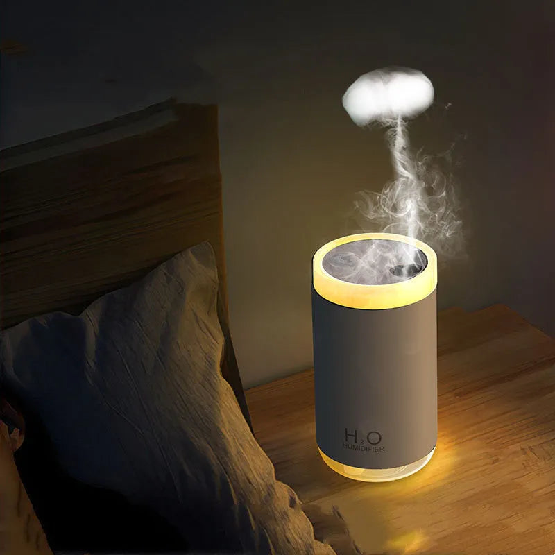 White USB humidifier with jellyfish spray mist effect and warm night light on a table.