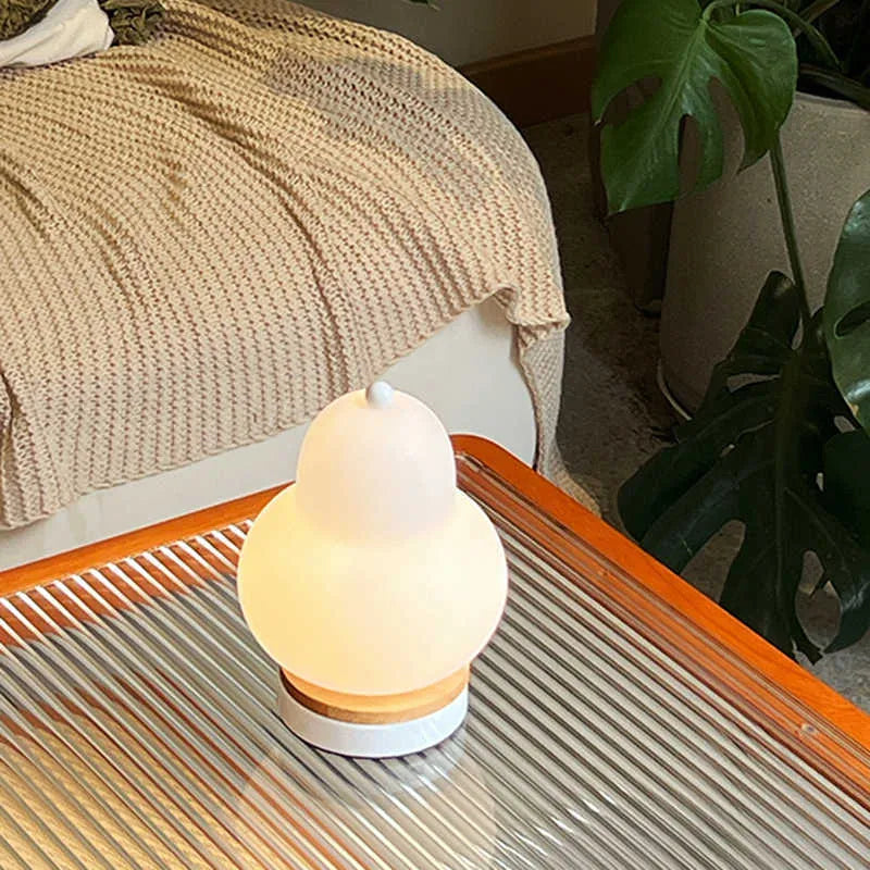 White pear rechargeable LED touch table lamp with PE shade on a bedside table