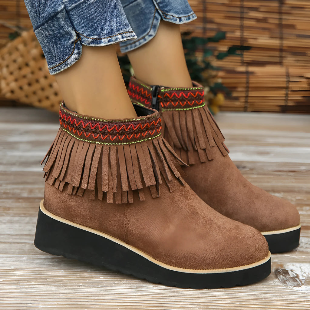 Women's dark brown suede wedge ankle boots with side zipper and tassel detail on a thick rubber sole.