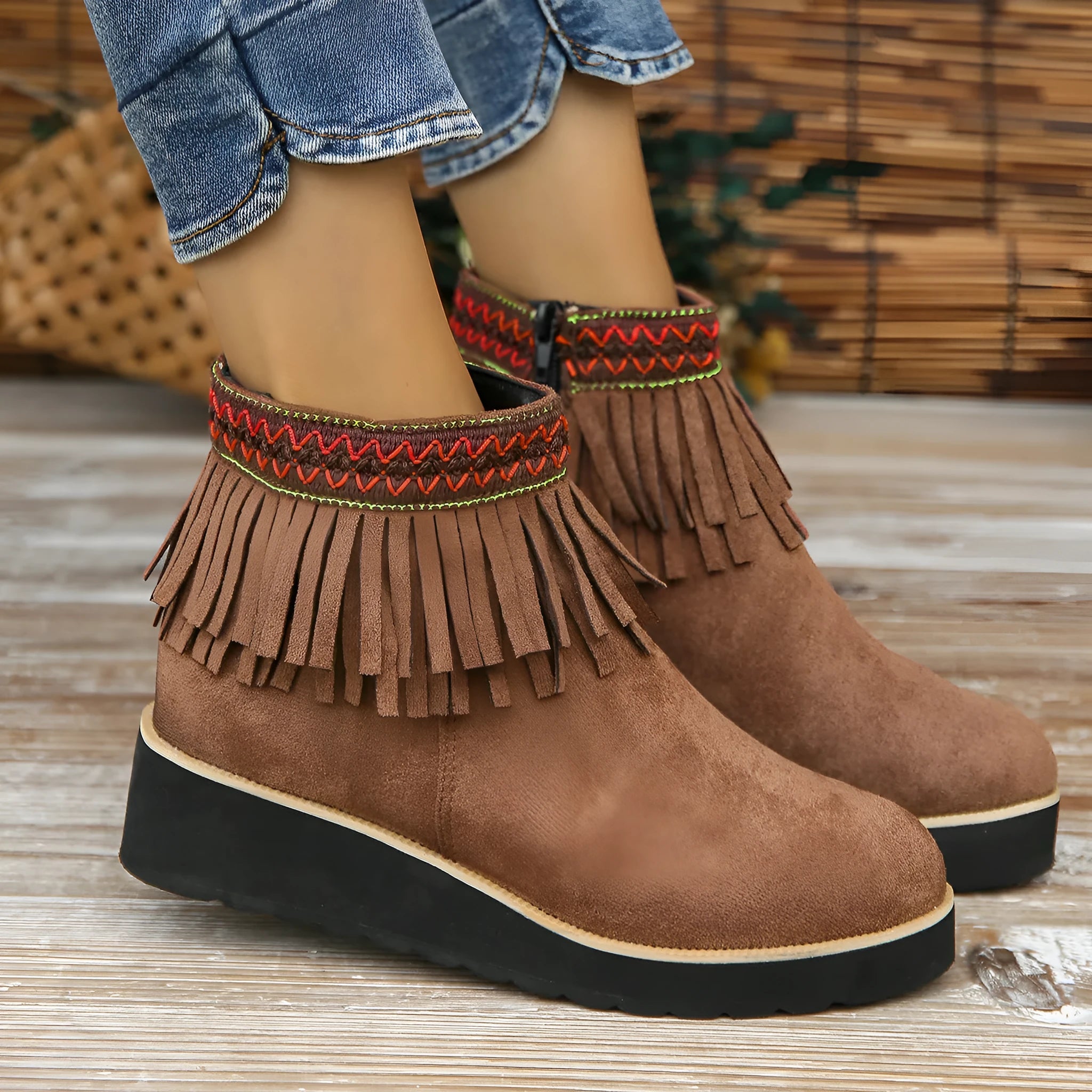 Women's dark brown suede wedge ankle boots with side zipper and tassel detail on a thick rubber sole.