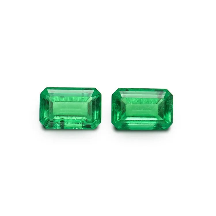 Loose cultivated emerald gemstone in Columbia green treasure colour on a white background.