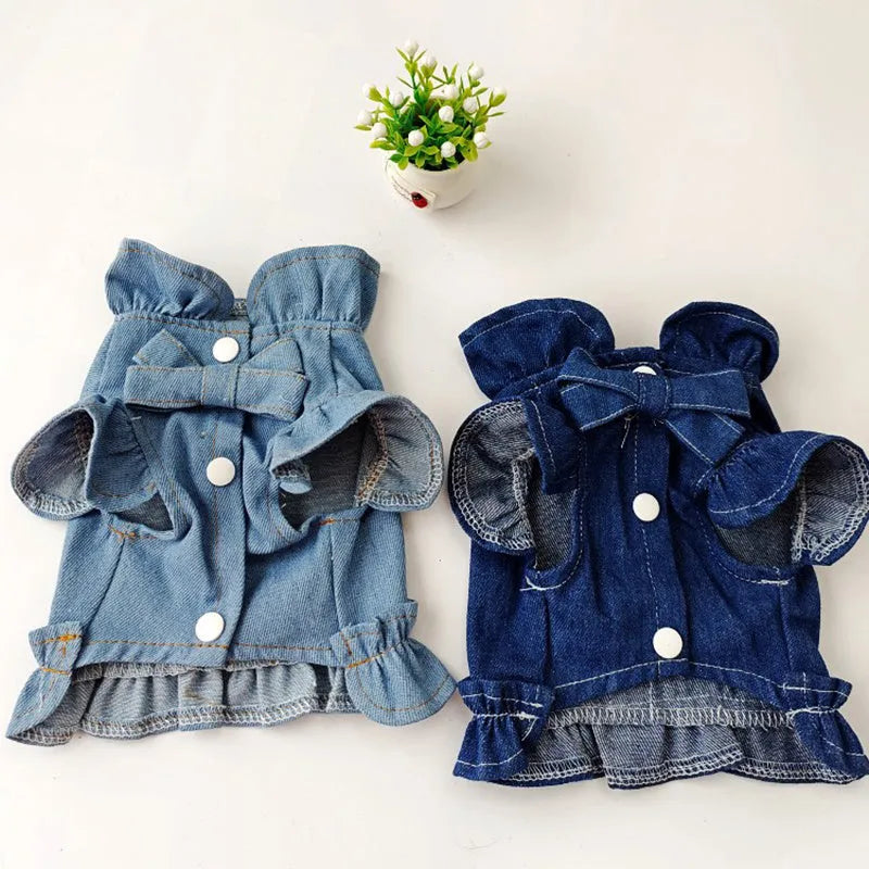 Blue denim dog dress with ruffle trim and metal leash attachment rings on chest and back