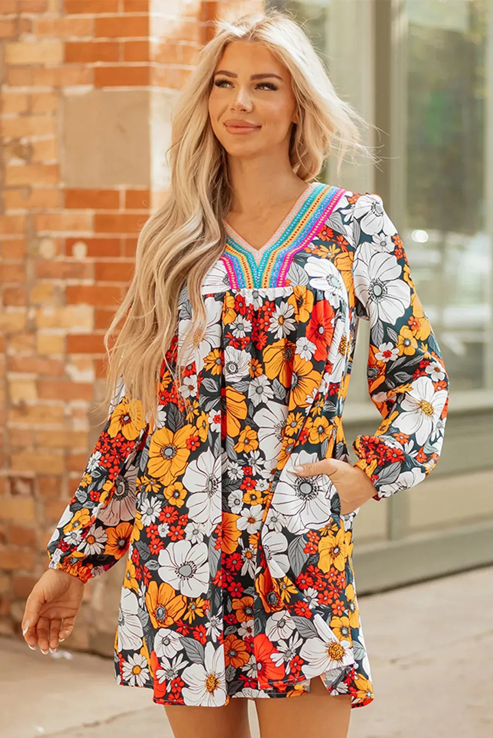 Orange floral print and striped lace V-neck long sleeve mini dress on a hanger.
