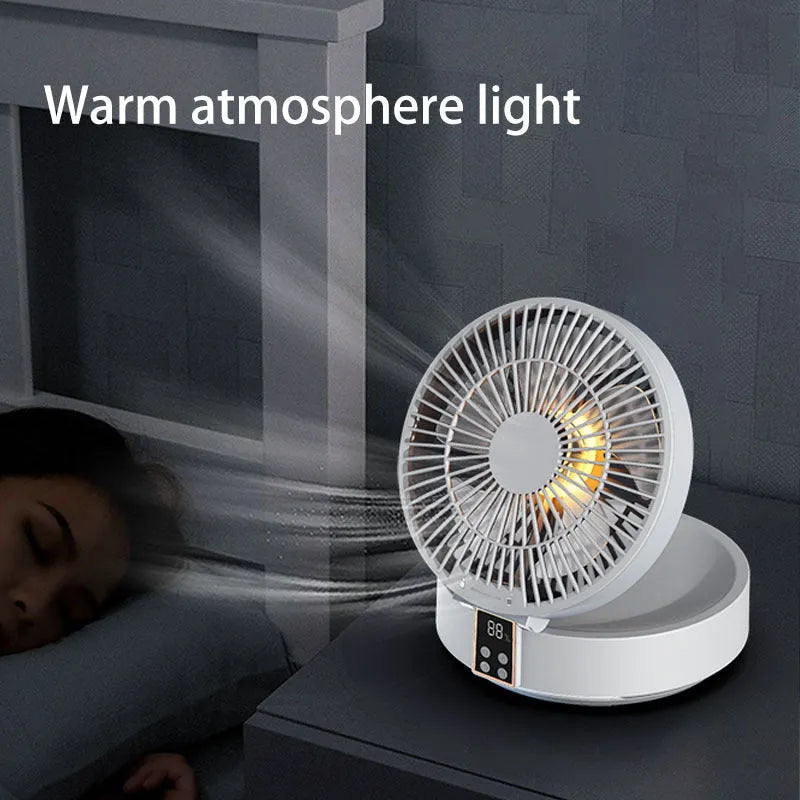 White portable folding fan with remote control on wooden desktop next to USB charging cable
