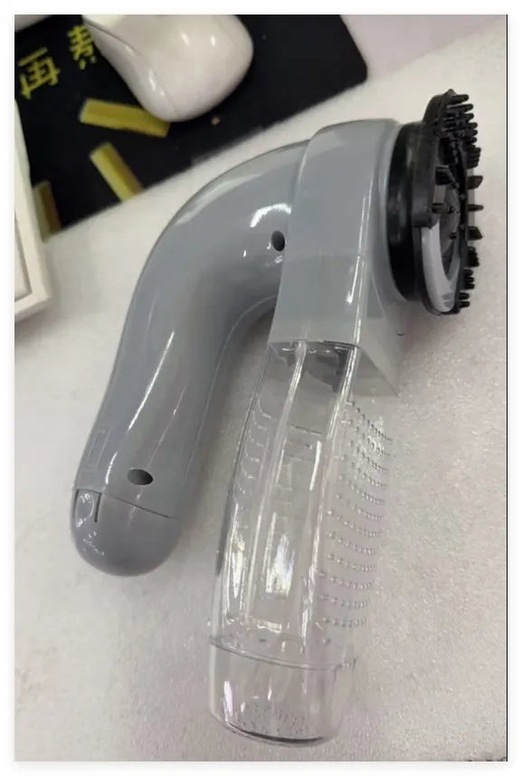 Grey handheld electric pet hair vacuum cleaner with soft rubber brush head for grooming dogs and cats