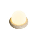 Cream coloured bedside night lamp with remote control on table