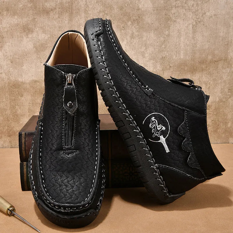 Men's black slip-on leather loafers with a round toe and rubber sole on a plain background.