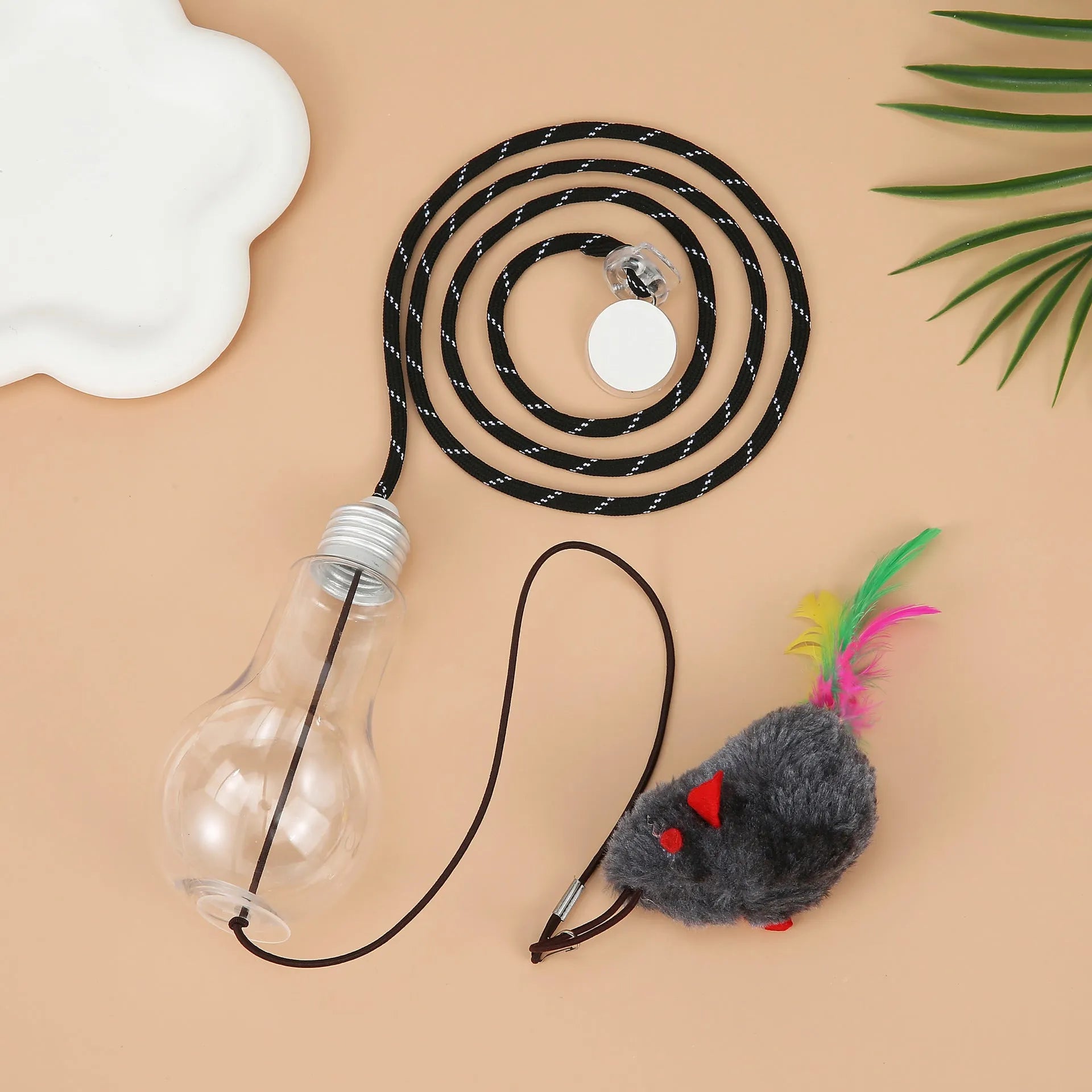 Grey and yellow interactive cat teaser toy with retractable rope, treat bulb, and dangling mouse, hanging from a door frame.