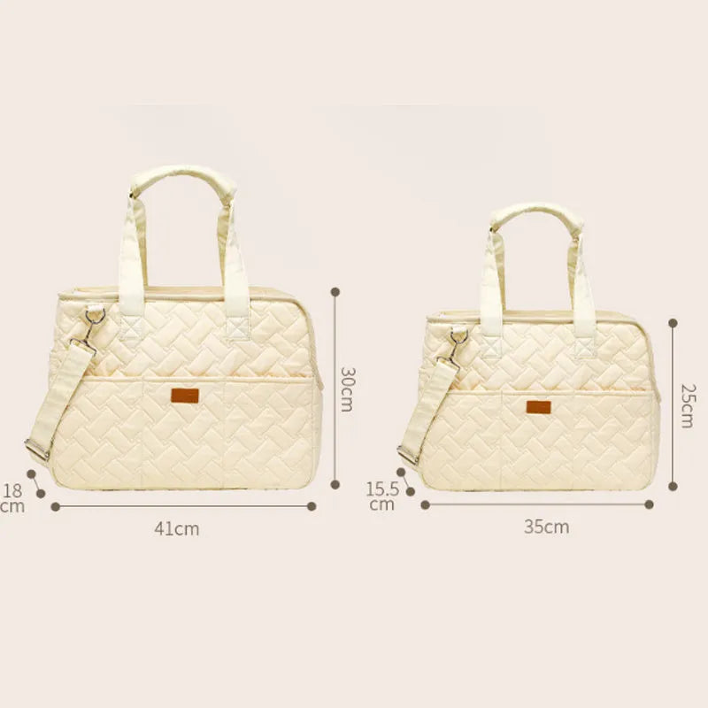 Grey pet carrier handbag with mesh panels and shoulder strap on a table
