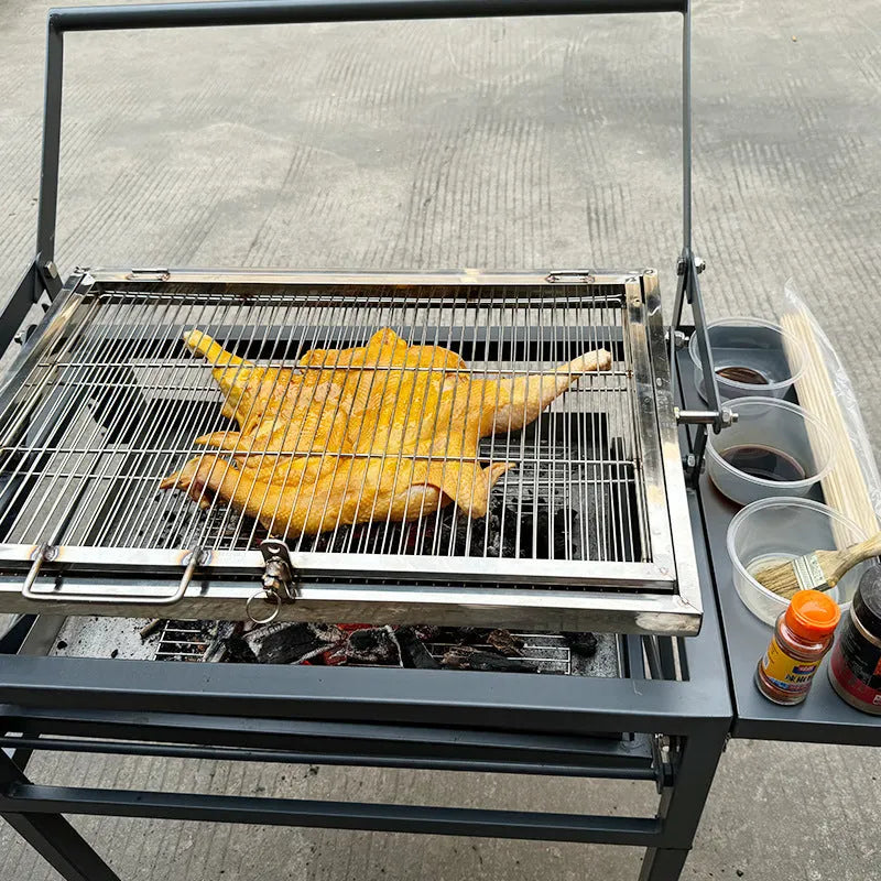 Large foldable Flip BBQ charcoal grill with detachable legs set up in a garden.