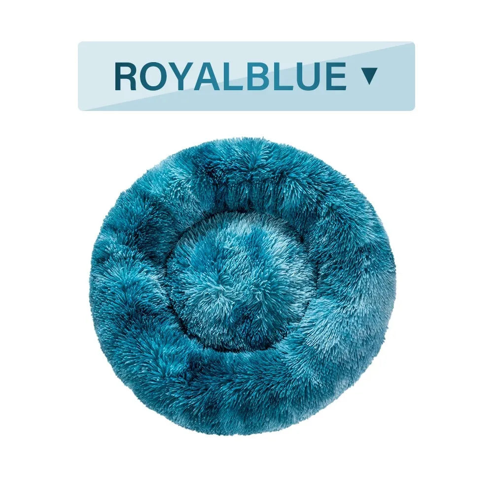 Fluffy donut-shaped pet bed in long plush material, showing raised edge and central well.