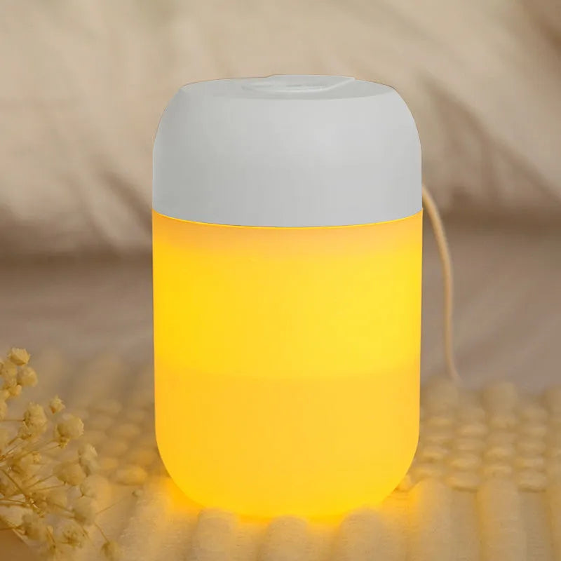 Small white cylindrical USB humidifier with aromatherapy function on a wooden desk.