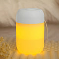 Small white cylindrical USB humidifier with aromatherapy function on a wooden desk.