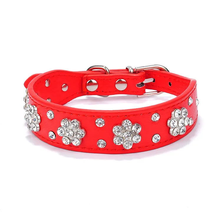 Close-up of a black PU leather dog collar with a sparkling rhinestone flower pattern and silver studs.
