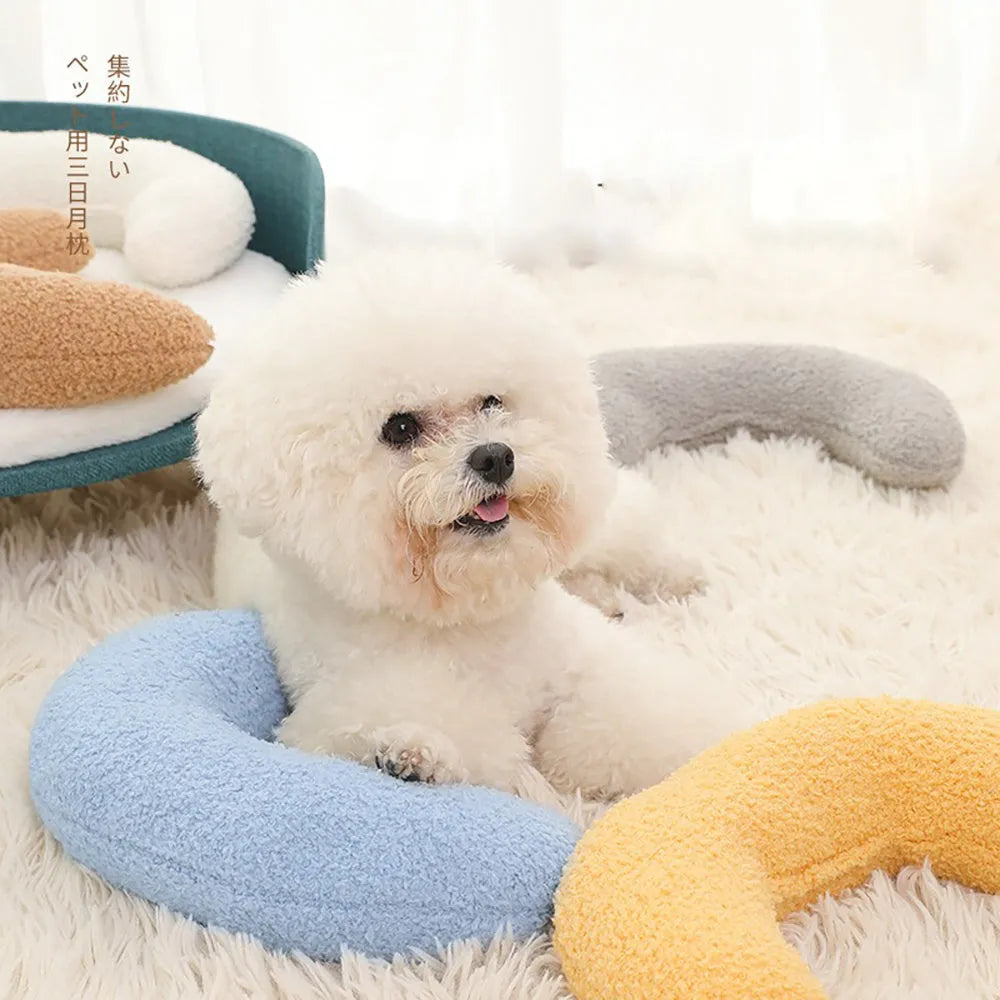 Blue U-shaped cat pillow with an adjustable fabric collar on a grey sofa