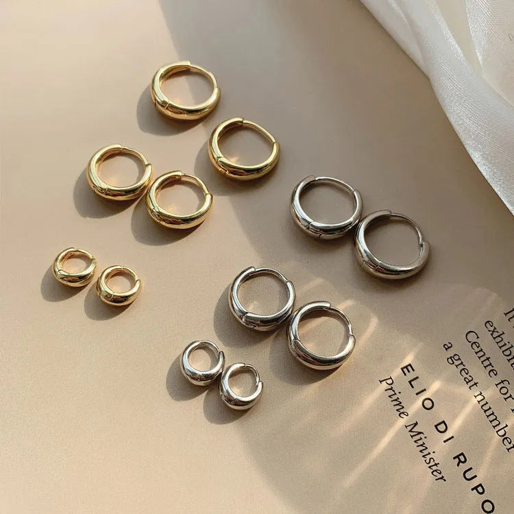 Women's minimalist copper water drop earrings in gold and silver, shown in small, medium, and large sizes.