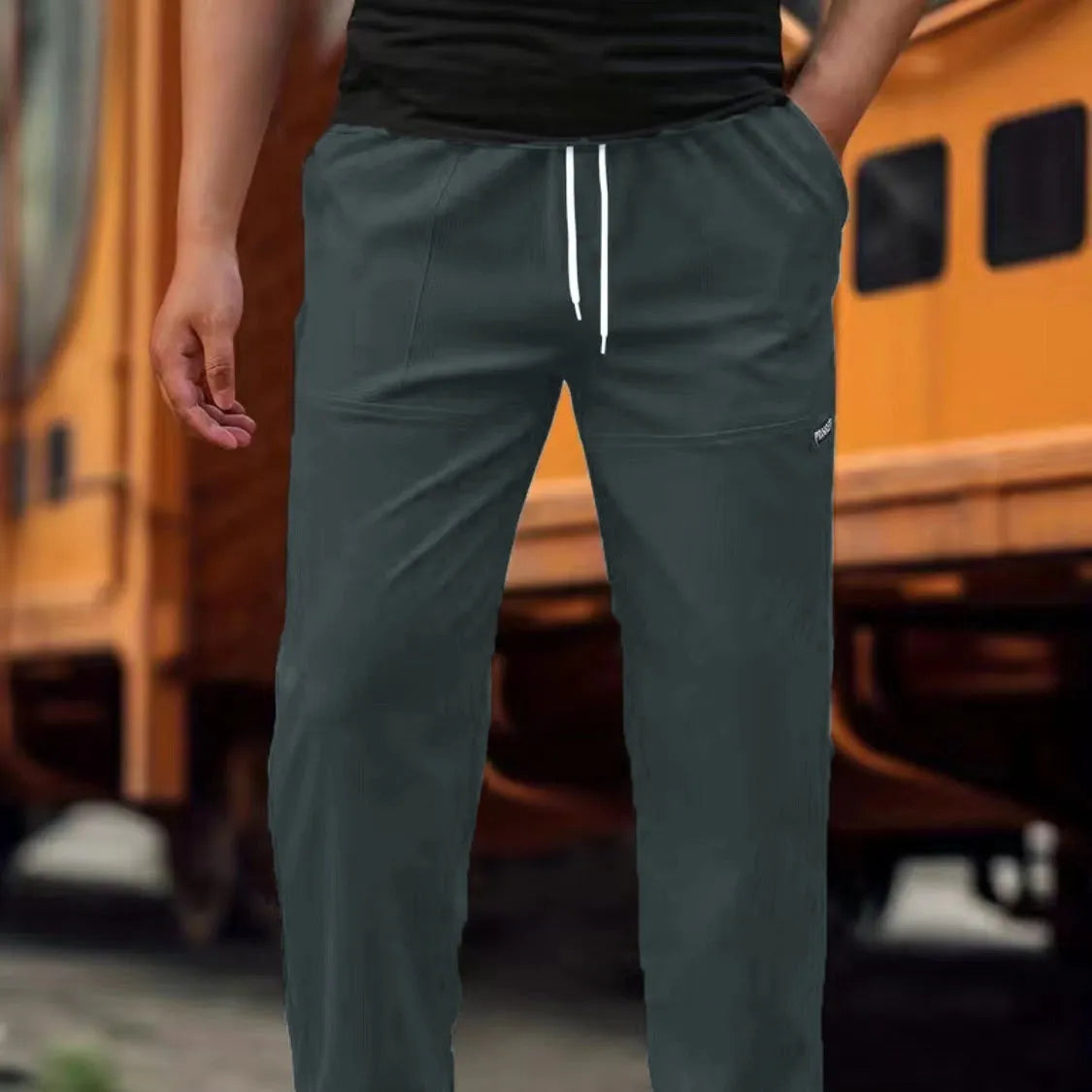 Man wearing lightweight grey polyester trousers, showcasing fit and casual style for spring or autumn.