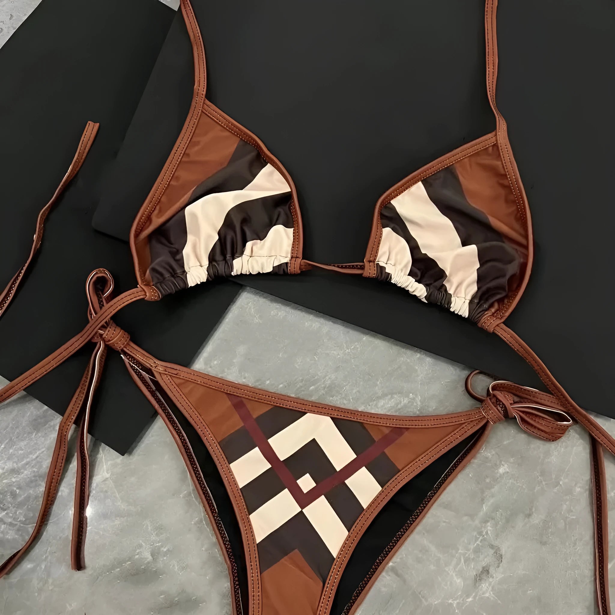 Women's black and white floral bikini set with split briefs on a beach
