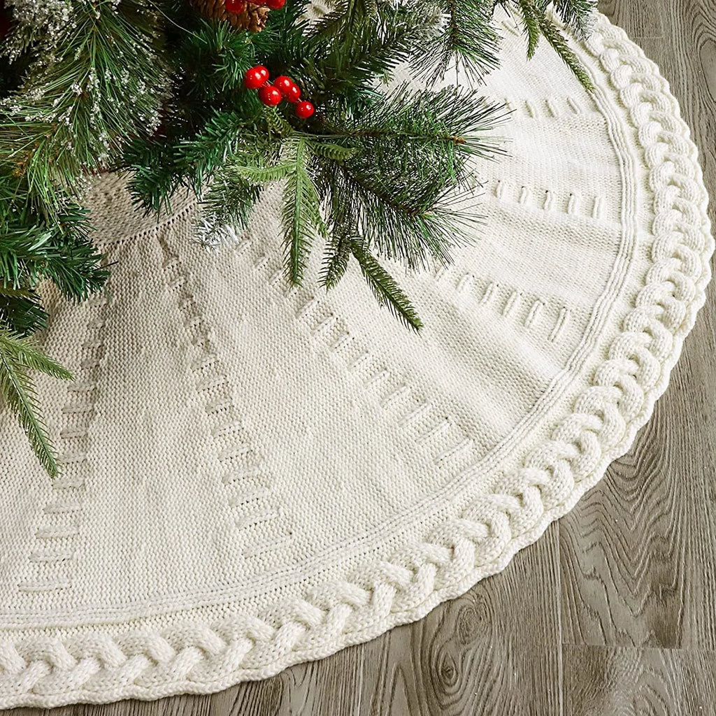 Red knitted wool Christmas tree skirt with 122cm diameter on floor under decorated tree