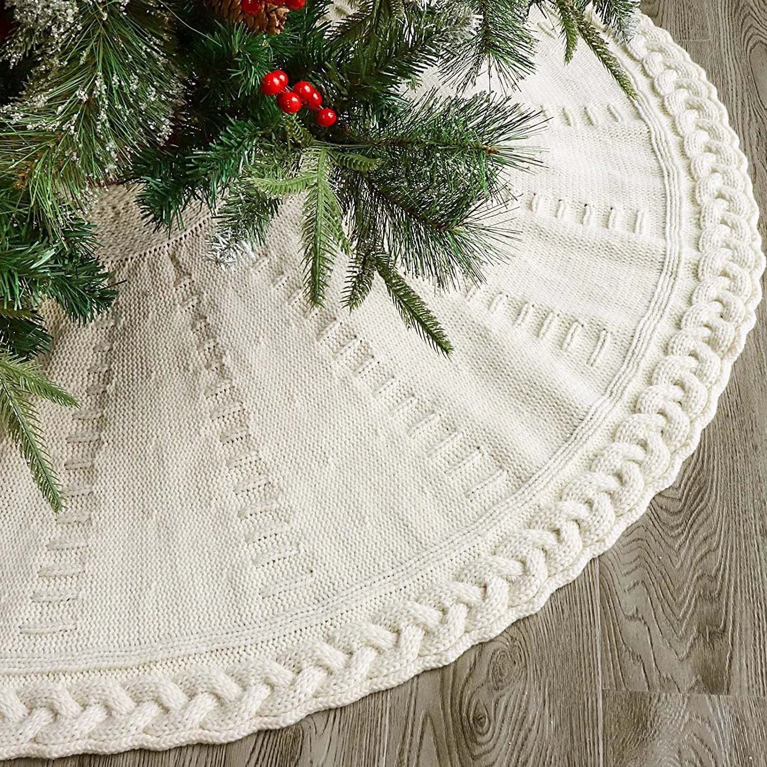Red knitted wool Christmas tree skirt with 122cm diameter on floor under decorated tree