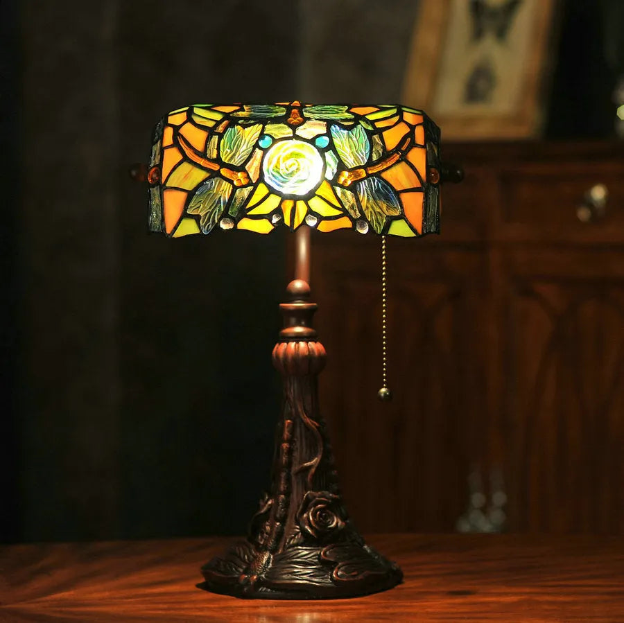Tiffany table lamp with coloured glass lampshade and stained glass resin base on wooden desk