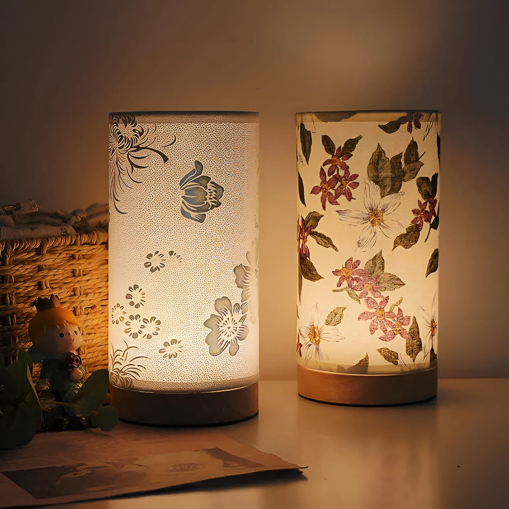 Creative floral fabric table lamp with remote control, warm LED light, black oil painting pattern on a bedside table