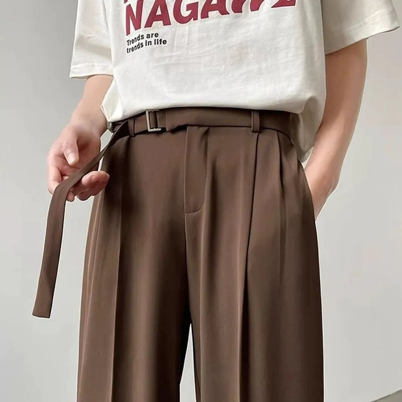 A pair of thin, black, loose-fit wide leg trousers with a straight leg opening, laid flat.