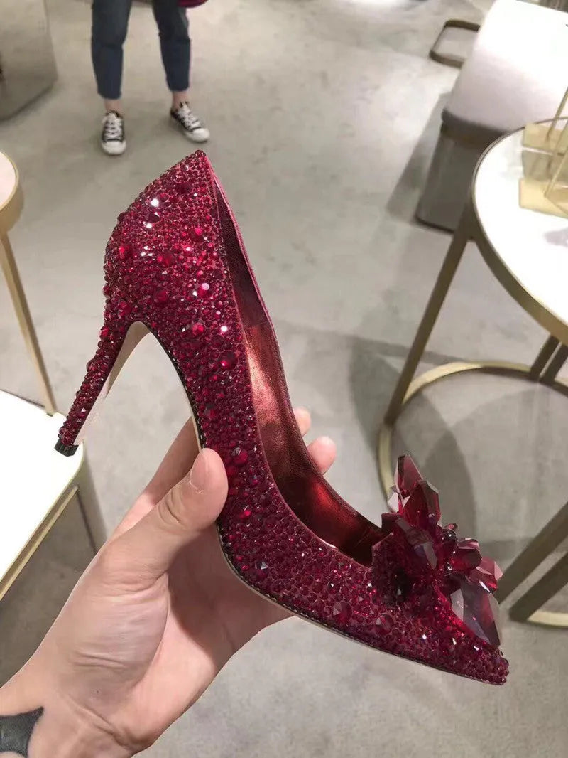 Gold women's pointed toe high heels with rhinestone decoration and a stiletto heel.