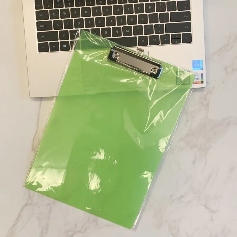 A4 transparent plate clipboard with metal clip, shown in blue colour on a desk with paper.