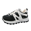 Black and white low-top lace-up sneakers with round toe and rubber sole