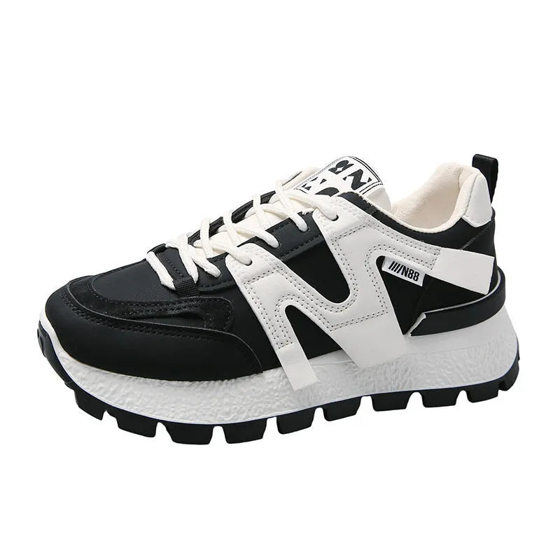 Black and white low-top lace-up sneakers with round toe and rubber sole