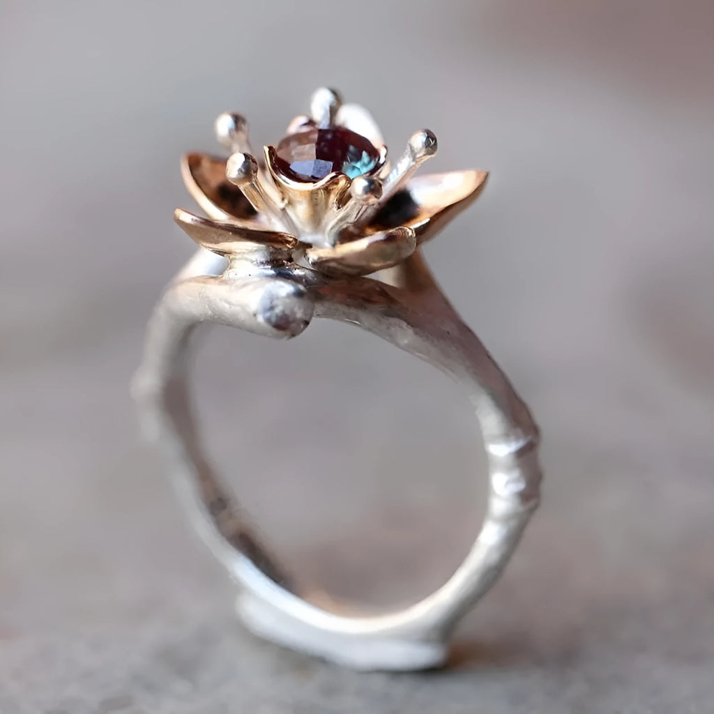 Silver two-tone floral geometric alloy ring for women on a grey background, showing detail.